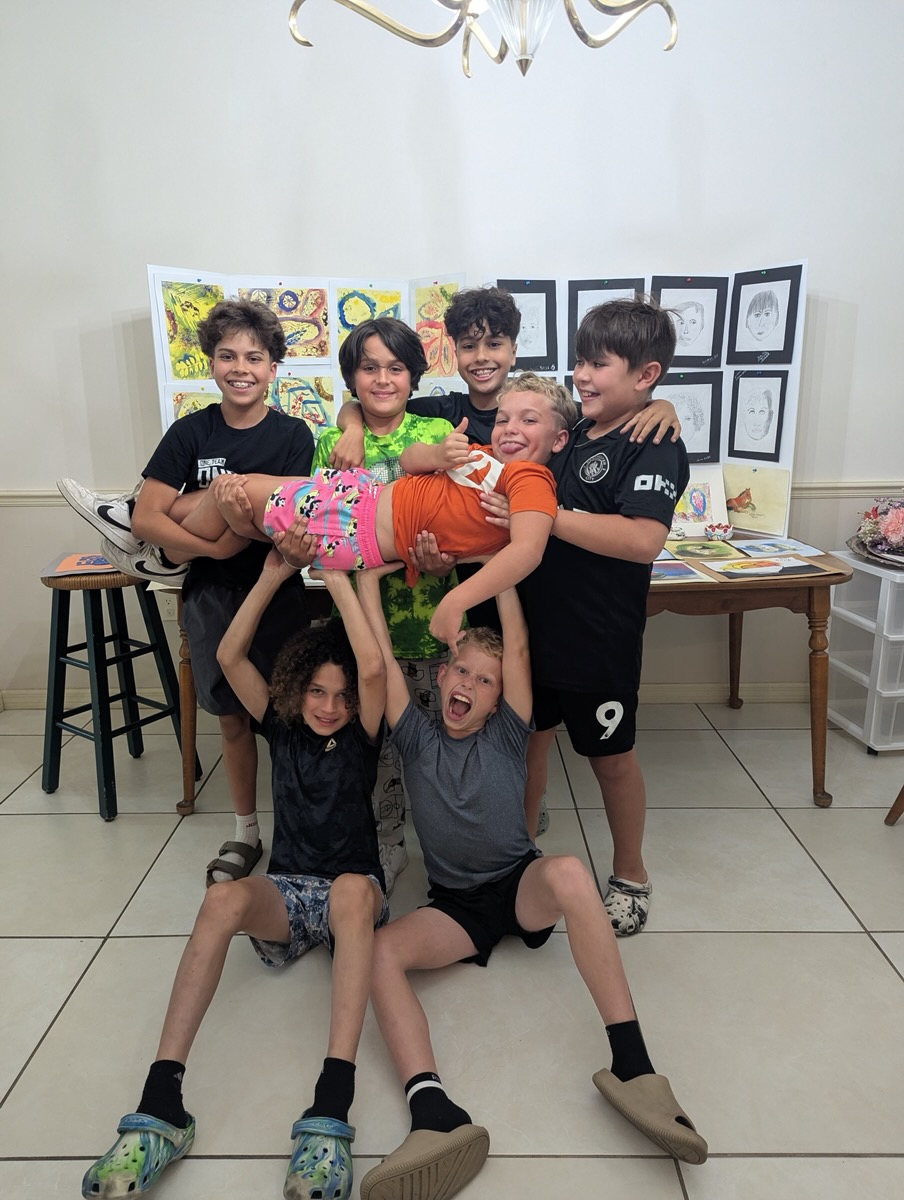 Students gathered in front of a display of their artwork